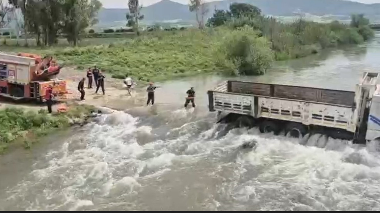 Azgın sularda kamyonda can pazarı: Halatlarla kurtardılar